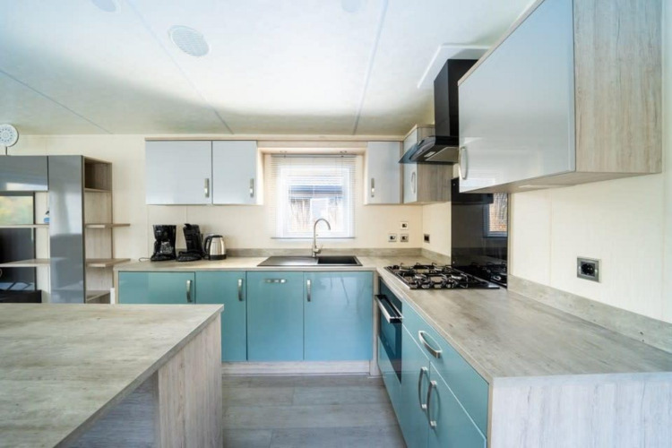 Cocina moderna en la cabaña Berkel en De Wije Werelt, Países Bajos, con gabinetes azules y estufa