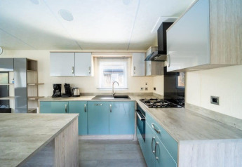 Cocina moderna en la cabaña Berkel en De Wije Werelt, Países Bajos, con gabinetes azules y estufa