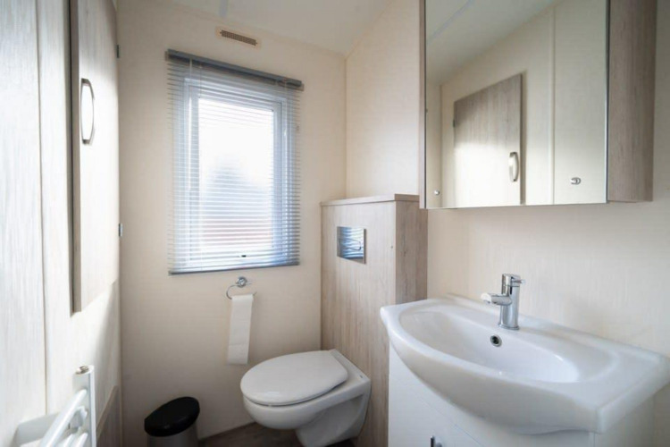 Baño moderno y limpio en la cabaña Berkel en De Wije Werelt, Países Bajos, con ventana y lavabo.