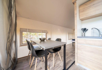 Indvendig udsigt over Glampingtent ved De Wije Werelt i Holland med spisebord og lille køkken.