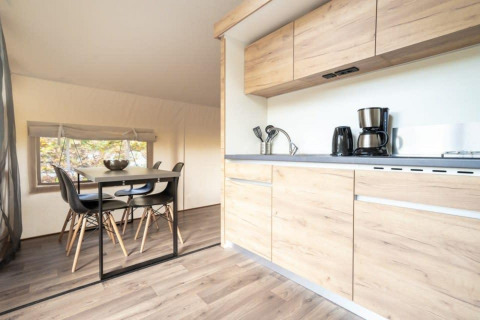 Modern kitchen and dining area inside a Glampingtent at De Wije Werelt in the Netherlands, wood accents.