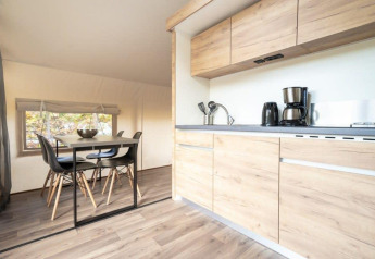 Modern kitchen and dining area inside a Glampingtent at De Wije Werelt in the Netherlands, wood accents.