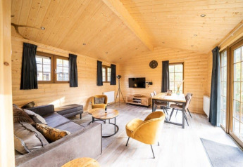 Intérieur en bois clair du lodge Boekhorst à De Wije Werelt, Pays-Bas, avec mobilier moderne et grandes fenêtres.