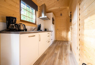 Moderne houten keuken met witte kasten in lodge Boekhorst, De Wije Werelt, Nederland.