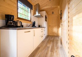 Modern wood kitchen with white cabinets and coffee maker at Boekhorst lodge in De Wije Werelt, Netherlands.