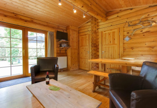 Interieur van lodge Boekhorst aan De Wije Werelt in Nederland, met houten muren en gezellige zithoek.
