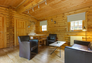 Gezellig binnenzicht van Boekhorst-lodge bij De Wije Werelt, Nederland, met lederen stoelen en houtaccenten.