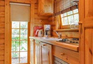 Houten keuken in lodge Boekhorst bij De Wije Werelt, Nederland, met apparaten en natuurlijk lichtinval.
