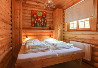 Cozy wooden bedroom at Boekhorst, De Wije Werelt, Netherlands, with double bed, painting, and window.