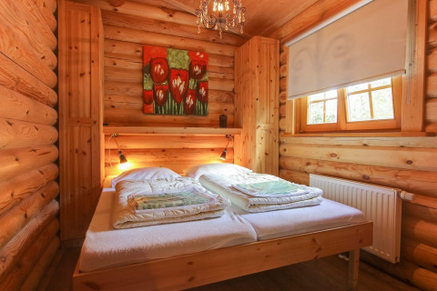 Chambre en bois chaleureuse à Boekhorst, De Wije Werelt, Pays-Bas, avec lit double et une grande fenêtre.