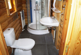 Moderne badkamer in een blokhut bij Boekhorst, De Wije Werelt, Nederland, met douche, wastafel en toilet.