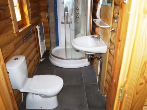 Moderne badkamer in een blokhut bij Boekhorst, De Wije Werelt, Nederland, met douche, lavabo en toilet.