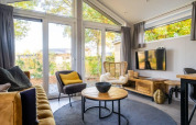 Intérieur lumineux du lodge Berkel à De Wije Werelt, Pays-Bas, avec de grandes fenêtres et une décoration moderne.