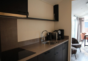 Modern kitchenette in Berkel Lodge at De Wije Werelt, Netherlands, featuring coffee machine and dining area.