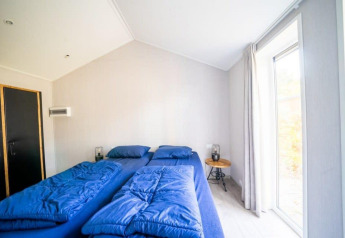 Bedroom at Berkel lodge at De Wije Werelt, Netherlands, featuring two single beds with blue bedding.