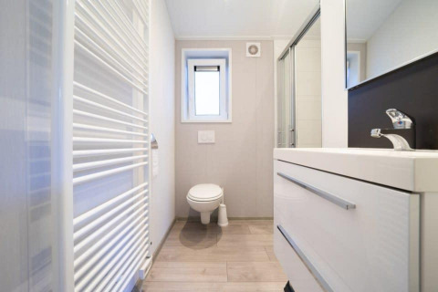 Salle de bain moderne au lodge Berkel à De Wije Werelt, Pays-Bas, avec toilettes, lavabo et douche.