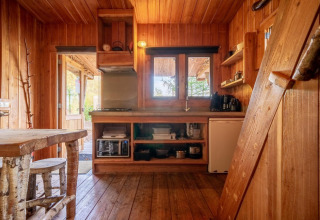 Houten interieur van de Nature Lodge aan De Wije Werelt in Nederland, met keuken en eetruimte.