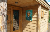 Entrada de una pequeña casa de madera con retrato de Van Gogh en la pared en De Wije Werelt, Países Bajos.