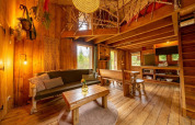 Cozy living room of Nature Lodge at De Wije Werelt, Netherlands, featuring rustic wood decor and sunlight.
