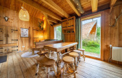 Binnenzicht van een gezellige houten lodge met grote ramen bij Nature Lodge op De Wije Werelt, Nederland.