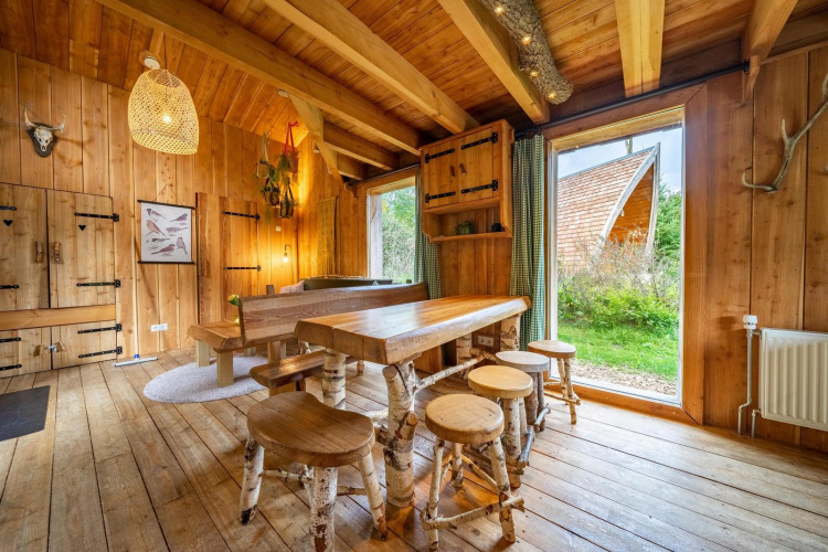 Interieur van een gezellige houten lodge met grote ramen bij Nature Lodge op De Wije Werelt in Nederland.
