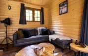 Salon confortable d'un lodge à Boekhorst, De Wije Werelt, Pays-Bas, avec murs en bois et canapé moderne.