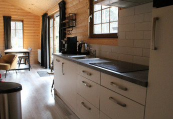 Modern kitchen and dining area inside Boekhorst lodge at De Wije Werelt, Netherlands, wooden interior.