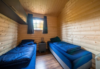 Acogedora habitación doble con paredes de madera en la Boekhorst lodge de De Wije Werelt, Países Bajos.