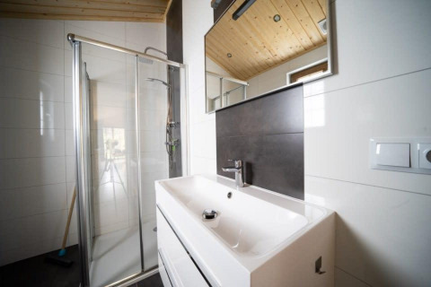Bagno moderno con box doccia, lavandino bianco e specchio al Boekhorst, De Wije Werelt, Paesi Bassi.