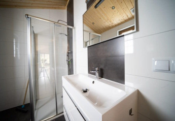 Modern bathroom with glass shower, white sink and mirror at Boekhorst lodge in De Wije Werelt, Netherlands.
