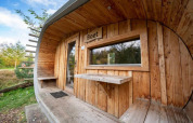 Exterior de la tiny house Boet en De Wije Werelt, Países Bajos, con revestimiento de madera y vista natural.