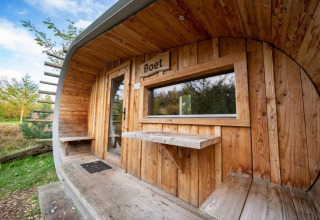 Exterior de la tiny house Boet en De Wije Werelt, Países Bajos, con revestimiento de madera y vista natural.