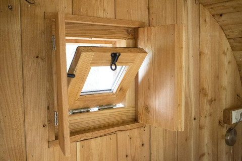 Ventana de madera abierta dentro de la tiny house Boet en De Wije Werelt, Países Bajos, vista interior.