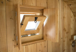 Ventana de madera abierta dentro de la tiny house Boet en De Wije Werelt, Países Bajos, vista interior.
