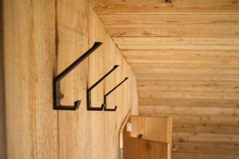 Ganchos metálicos en una pared de madera dentro de una tiny house en Boet, De Wije Werelt, Países Bajos.