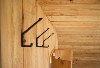 Ganchos metálicos en una pared de madera dentro de una tiny house en Boet, De Wije Werelt, Países Bajos.