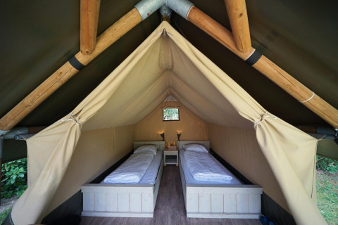 Innenraum eines Mini-Glamping-Zeltes bei De Wije Werelt in den Niederlanden mit zwei Einzelbetten.