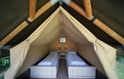 Indretning af Mini glamping telt på De Wije Werelt i Holland med to enkeltsenge og hyggelig belysning.