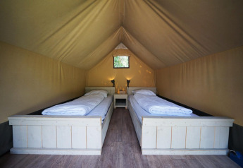 Indretning af safari mini-glamping telt på De Wije Werelt i Holland med to enkeltsenge og natbord.