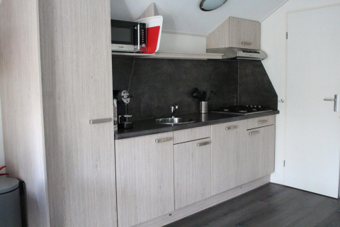 Moderne tekøkken i Boslodge på De Wije Werelt, Holland, med lyse skabe og apparater.