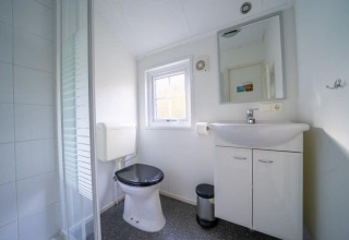 Bagno moderno e luminoso presso Boslodge a De Wije Werelt nei Paesi Bassi con wc, lavabo e cabina doccia.