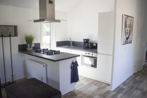 Cuisine blanche moderne avec plan de travail noir au Velthorst, De Wije Werelt, Pays-Bas, décorée d’un tableau.