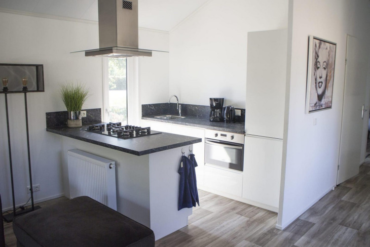 Cocina blanca moderna con encimera negra en Velthorst, De Wije Werelt, Países Bajos, con arte en la pared.