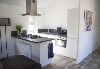 Cocina blanca moderna con encimera negra en Velthorst, De Wije Werelt, Países Bajos, con arte en la pared.