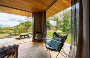 Vue depuis le lodge Fred à De Wije Werelt, Pays-Bas, avec des fauteuils confortables et nature paisible.