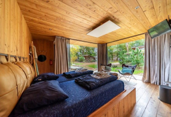 Fred-lodge på De Wije Werelt i Holland; hyggeligt soveværelse med træinteriør og udsigt til naturen.