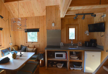 Interno accogliente di una casa sull’albero a De Wije Werelt nei Paesi Bassi, con cucina e tavolo da pranzo.