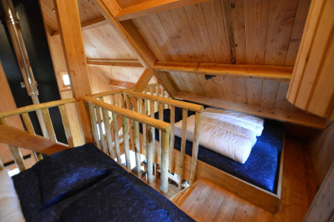 Soppalco con letti e pareti in legno nella Treehouse a De Wije Werelt, tiny house nei Paesi Bassi.