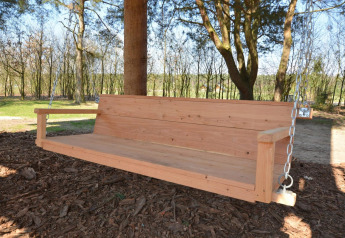 Holzschaukelbank im Freien, aufgehängt an einem Baum nahe dem Treehouse bei De Wije Werelt in den Niederlanden.