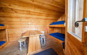 Intérieur de la tiny house Geurt à De Wije Werelt, Pays-Bas, avec des lits superposés et des murs en bois.